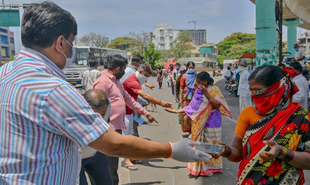 Người d&acirc;n ph&acirc;n ph&aacute;t đồ ăn miễn ph&iacute; ở Bangalore, Ấn Độ. Ảnh:  Manjunath Kiran/AFP via Getty Images.