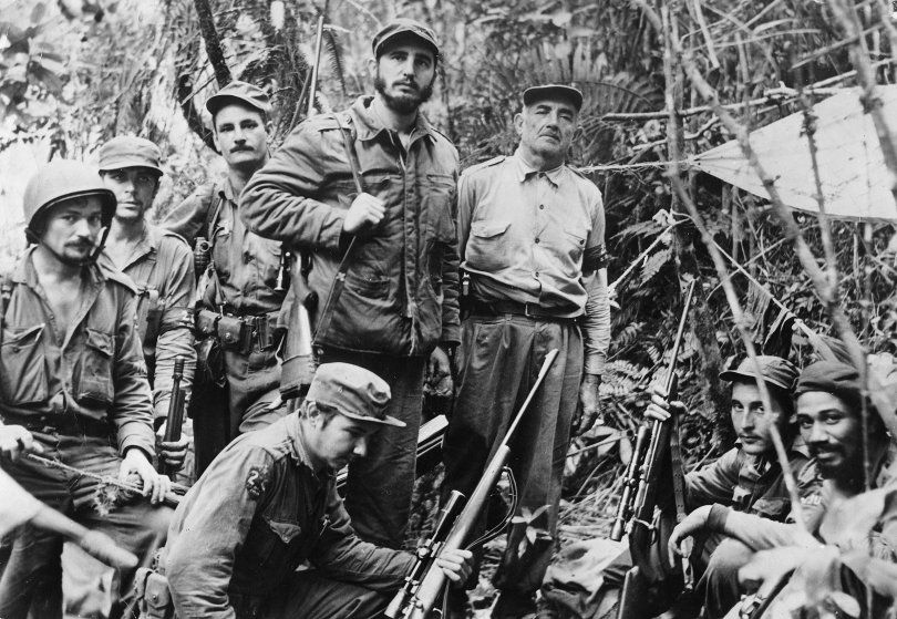 Fidel Castro with his command staff in a secret jungle hideout, 1958. From left: Guillermo Garcia, Ernesto Che Guevara, Universo Sanchez, Raul Castro (kneeling), Castro, Crescentio Perez, George Sotus and Juan Almeide. ullstein bild/Getty Images